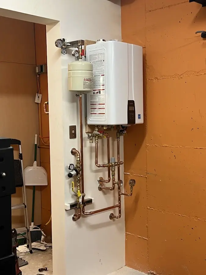 Plumbing technician inspecting water heater connections in Phenix City